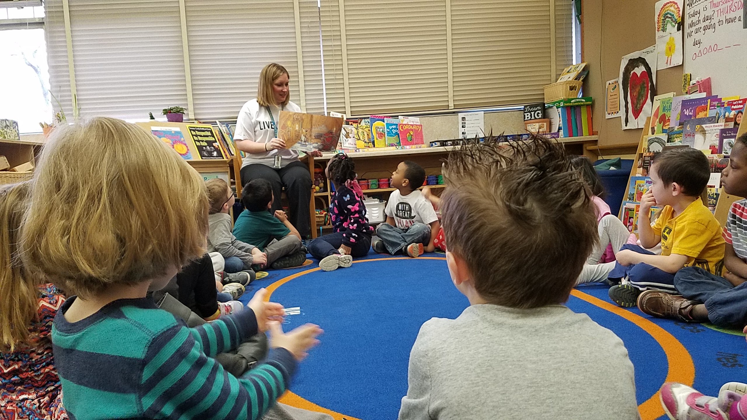 Volunteer reads to a classroom of children
