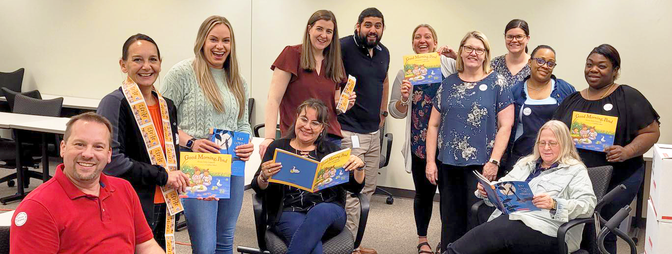 TH Foods staff pose after stickering books together.
