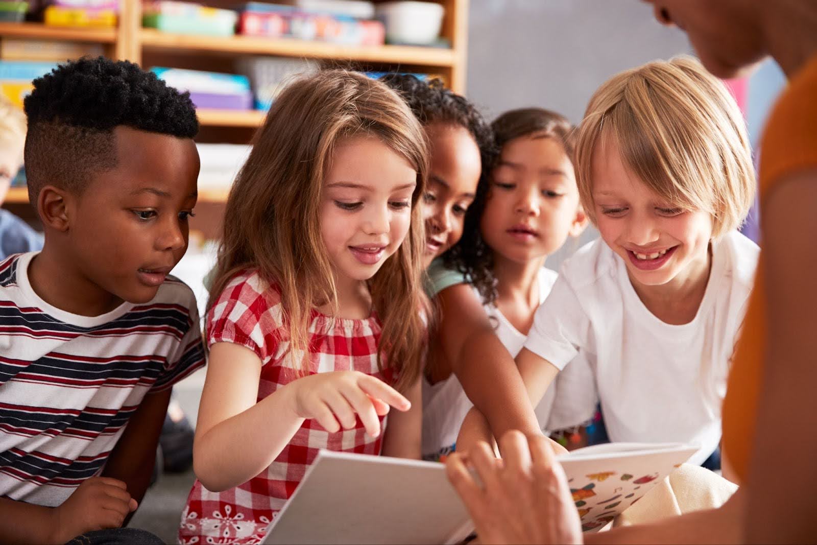 Young group of elementary children reading with teacher