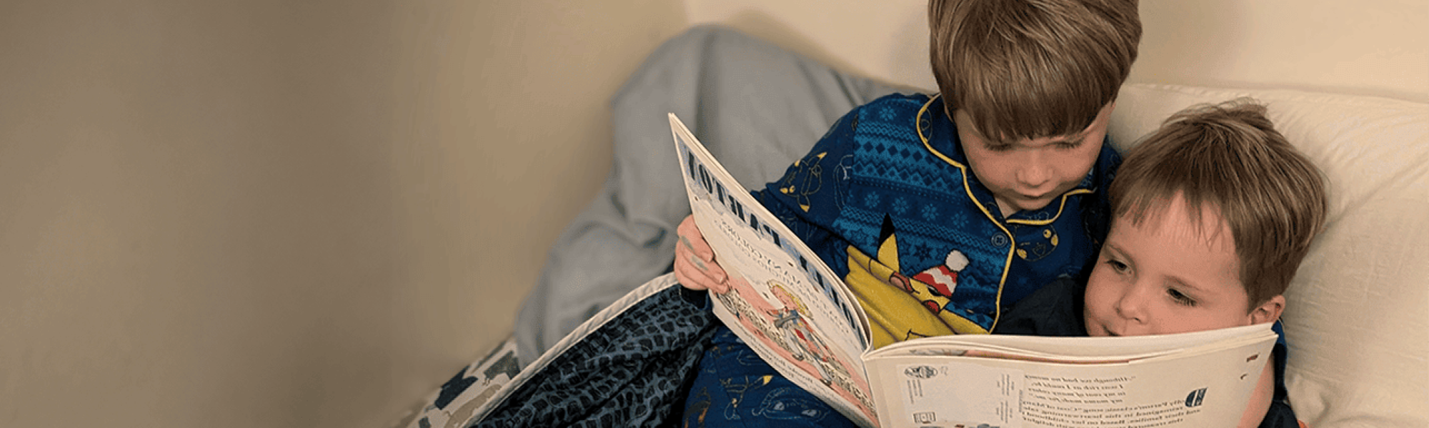 brothers reading together in bed