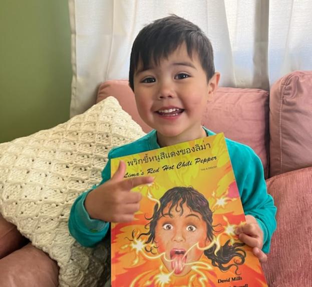 Young child with a book, smiling