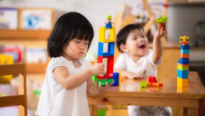 Girl and boy toddlers playing with blocks for early learning
